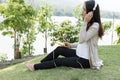 Young asian woman sitting in fresh spring grass listening to mus Royalty Free Stock Photo