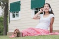 Young asian woman sitting in fresh spring grass listening to mus Royalty Free Stock Photo