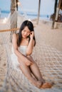 Young Asian woman sitting on hammock relax on beach, Beautiful female happy relax near sea. Lifestyle women travel on beach Royalty Free Stock Photo