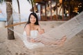 Young Asian woman sitting on hammock relax on beach, Beautiful female happy relax near sea. Lifestyle women travel on beach Royalty Free Stock Photo