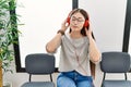 Young asian woman sitting wearing headphones at waiting room Royalty Free Stock Photo