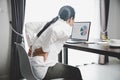 Young asian woman is sitting at work and has tension pain in her neck. Concept office syndrome backache pain from occupational Royalty Free Stock Photo