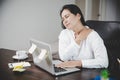 Young asian woman is sitting at work and has tension pain in her neck. Concept office syndrome backache pain from occupational Royalty Free Stock Photo