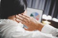 Young asian woman is sitting at work and has tension pain in her neck. Concept office syndrome backache pain from occupational Royalty Free Stock Photo