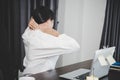 Young asian woman is sitting at work and has tension pain in her neck. Concept office syndrome backache pain from occupational Royalty Free Stock Photo