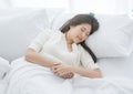 Young Asian woman sleeping in a white bed in the early morning. Royalty Free Stock Photo