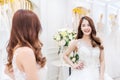 Young asian woman smiling and trying on wedding dress in a shop, asian bride look the mirror for beauty, Royalty Free Stock Photo