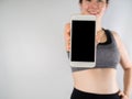 Young asian woman in sport bra hold smartphone, tablet, cell ph Royalty Free Stock Photo
