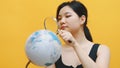 Young asian woman spy, holding globe and magnifying glass . Investigation and inspection Royalty Free Stock Photo