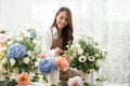 Young Asian woman stand at desk at home make beautiful floral compositions for sale Royalty Free Stock Photo