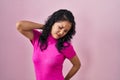 Young asian woman standing over pink background suffering of neck ache injury, touching neck with hand, muscular pain Royalty Free Stock Photo