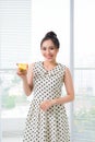 Young asian woman standing by window at home and drinking tea Royalty Free Stock Photo