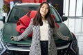 Young asian woman stands in front of car with red bow Royalty Free Stock Photo