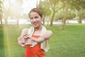 Young Asian woman stretching her hands before run in park with sunshine effect. Fitness and exercise concept. Royalty Free Stock Photo