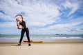 Young Asian woman is stretching or warm-up her body before exercise by running on the beach in the morning and get fresh air. Royalty Free Stock Photo