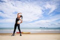 Young Asian woman is stretching or warm-up her body before exercise by running on the beach in the morning and get fresh air. Royalty Free Stock Photo