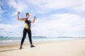 Young Asian woman is stretching or warm-up her body before exercise by running on the beach in the morning and get fresh air. Royalty Free Stock Photo