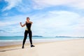 Young Asian woman is stretching or warm-up her body before exercise by running on the beach in the morning and get fresh air. Royalty Free Stock Photo