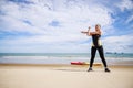 Young Asian woman is stretching or warm-up her body before exercise by running on the beach in the morning and get fresh air. Royalty Free Stock Photo