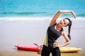 Young Asian woman is stretching or warm-up her body before exercise by running on the beach in the morning and get fresh air. Royalty Free Stock Photo