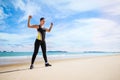 Young Asian woman is stretching or warm-up her body before exercise by running on the beach in the morning and get fresh air. Royalty Free Stock Photo