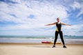 Young Asian woman is stretching or warm-up her body before exercise by running on the beach in the morning and get fresh air. Royalty Free Stock Photo