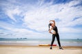 Young Asian woman is stretching or warm-up her body before exercise by running on the beach in the morning and get fresh air. Royalty Free Stock Photo