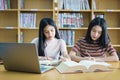 Young Asian woman student study and take notes with book in library. F Royalty Free Stock Photo