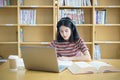 Young Asian woman student study and take notes with book in library. F Royalty Free Stock Photo