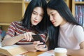 Young Asian woman student study and take notes with book in library. F Royalty Free Stock Photo