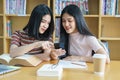 Young Asian woman student study and take notes with book in library. F Royalty Free Stock Photo