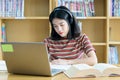 Young Asian woman student study and take notes with book in library. F Royalty Free Stock Photo