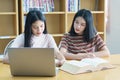 Young Asian woman student study and take notes with book in library. F Royalty Free Stock Photo