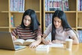 Young Asian woman student study and take notes with book in library. F Royalty Free Stock Photo