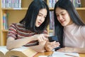 Young Asian woman student study and take notes with book in library. F Royalty Free Stock Photo