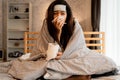 Young Asian woman suffering from cold and illness and lying in bed with tissue at home