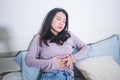 Young Asian woman suffering menses abdominal cramp - sick and tired Chinese girl lying on bed having having period pain holding