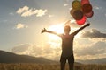 Young asian woman on sunset grassland with colored balloons Royalty Free Stock Photo