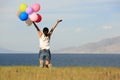 Young asian woman on sunset grassland with colored balloons Royalty Free Stock Photo