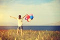 Young asian woman on sunset grassland with colored balloons Royalty Free Stock Photo