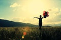 Young asian woman on sunset grassland with colored balloons Royalty Free Stock Photo