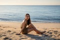 Young asian woman in swimwear relaxing and sunbathing on the beach in the morning Royalty Free Stock Photo