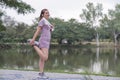 Young Asian woman takes care of her health by exercising. Stretch your legs in the park