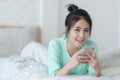 Young Asian woman taking selfie photo in bedroom