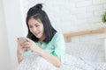 Young Asian woman taking selfie photo in bedroom