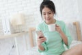 Young Asian woman taking selfie photo in bedroom