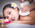 Young woman is taking Thai Herbal ball hot compress massage in an authetic spa authentic
