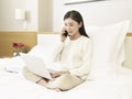 Young asian woman talking on cellphone on bed Royalty Free Stock Photo