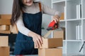 Young asian woman taping up a cardboard box in home office SME e-commerce business, relocation and new small business Royalty Free Stock Photo