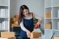 Young asian woman taping up a cardboard box in home office SME e-commerce business, relocation and new small business Royalty Free Stock Photo